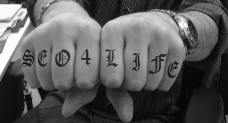SEO tattoo across knuckles