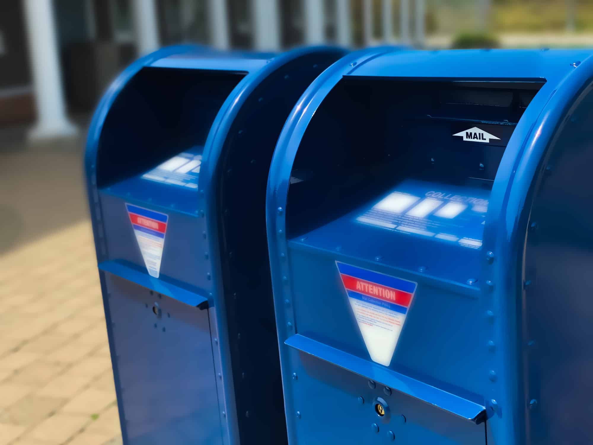 two traditional blue postal mailboxes side by side