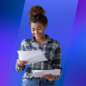 A woman smiling and reading mail in front of a blue background
