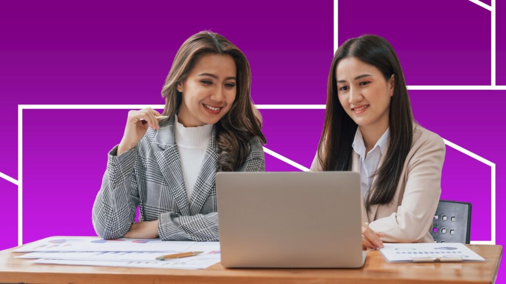 Two women looking at a laptop in front of a purple geographic background.