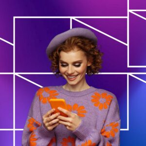 A woman in a floral sweater looking at her phone. She's standing in front of a purple and blue geometric background.