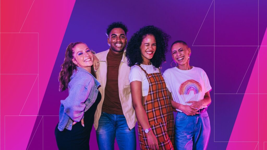 Four young adults stand close together, smiling and laughing toward the camera against a vibrant pink and purple gradient background with geometric line accents, conveying a sense of connection, joy, and inclusivity.