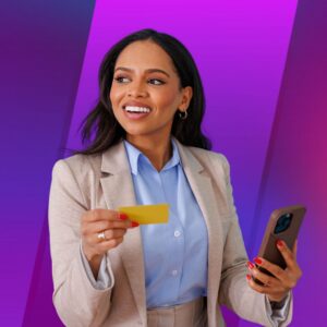 A woman in business attire smiles while holding a yellow credit card in one hand and a smartphone in the other, set against a purple gradient background, suggesting confident digital purchasing or mobile payment use.